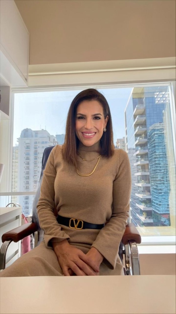 Dra. Daniela em sala de atendimento com vista para São Paulo